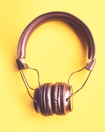 Wireless Headphones on colorful background. Flat lay concept: earphones on pastel backgrounds vertical cropの写真素材
