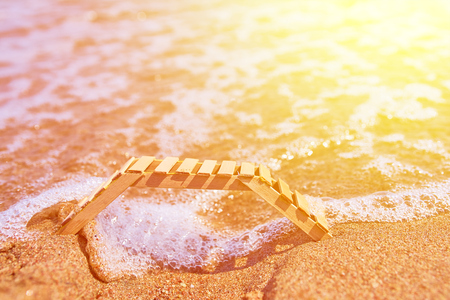 Wooden deckchair on a tropical sand beach. Empty wooden chairs or deckchairs on wood shore overlooking scenic calm river.の写真素材