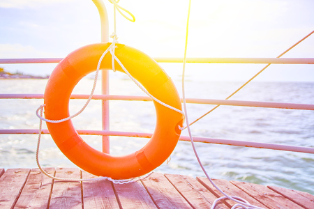 Orange lifebuoy with rope on a wooden pier near sea. Lifebuoy with rope on a wooden pier near sea.の写真素材