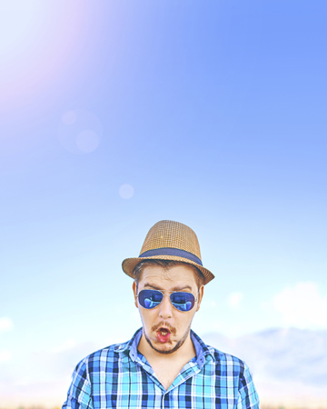 A man on the sunny beach, surprised by something. Vertical crop with copyspaceの写真素材