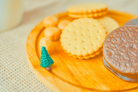 Miniature Christmas tree with cookies on the table on a festive evening