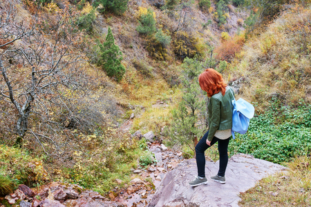 Beauty woman hiker with backpack walking in mountains forest.の写真素材