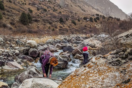 Group of tourists with large backpacks are on mountain. Group of Friends of hikers going up the mountain wood stream, overcoming obstacles.の写真素材