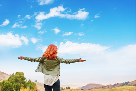 Woman enjoys the views spreading her hands to the sides in the mountains enjoying solitude with natureの写真素材