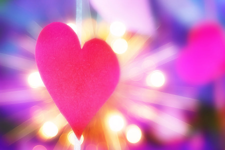 Concept of Valentines day. cut out red paper in the form of a heart on the background of bright bulbsの写真素材