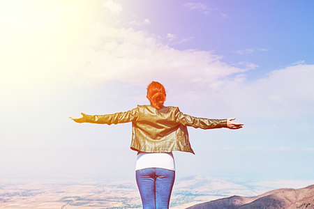 Woman enjoys the views spreading her hands to the sides in the mountains enjoying solitude with natureの写真素材
