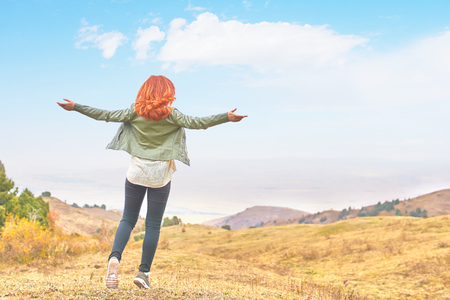 Woman enjoys the views spreading her hands to the sides in the mountains enjoying solitude with natureの写真素材