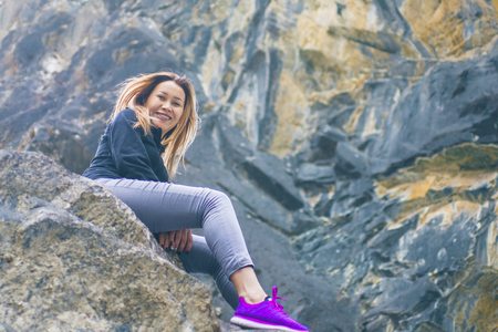 Female sitting on the rock , relaxing on the top of the mountain, silhouette.の写真素材