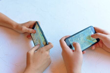 Bishkek, Kyrgyzstan - January 17, 2019: Two friends play pubg coop multiplayer battle royale game on iPhone and Android. Gameplay action jumping from planeのeditorial素材