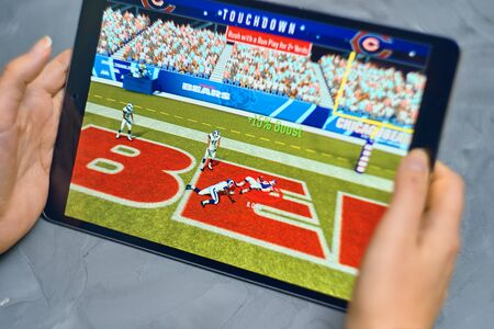 Bishkek, Kyrgyzstan - January 21, 2019: Girl playing a mobile game madden nfl of ea sports company...