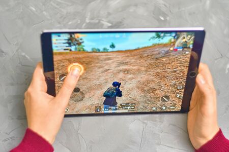 Bishkek, Kyrgyzstan - January 21, 2019: Woman playing pubg coop multiplayer battle royale game on Apple ios tablet iPad Proのeditorial素材