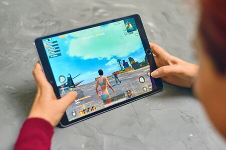 Bishkek, Kyrgyzstan - January 21, 2019: Woman playing pubg coop multiplayer battle royale game on Apple ios tablet iPad Proのeditorial素材