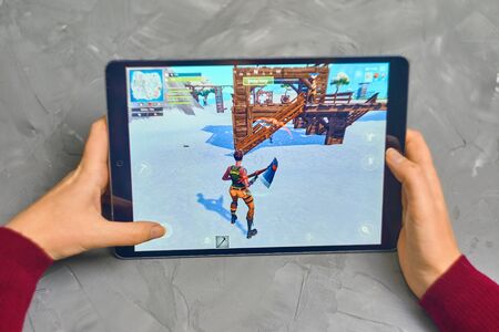 Bishkek, Kyrgyzstan - January 21, 2019: Woman playing fortnite game of epic games company on Apple ios tablet iPad Pro. Gameplay Actionのeditorial素材
