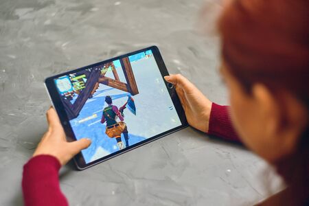 Bishkek, Kyrgyzstan - January 21, 2019: Woman playing fortnite game of epic games company on Apple ios tablet iPad Pro. Gameplay Actionのeditorial素材