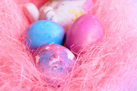 Space galactic Easter eggs in a pink nest next to a rabbitの写真素材