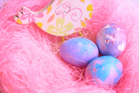 Space galactic Easter eggs in a pink nest next to a chickenの写真素材