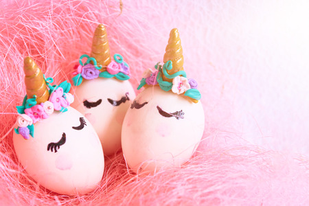 Three Easter eggs unicorns in a pink nestの写真素材