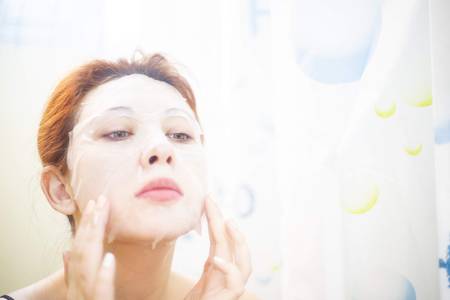 Young girl with facial mask white background. Cosmetic procedure. Beauty spa and cosmetology.