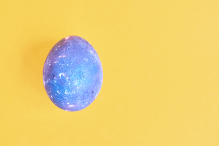 Cosmic galactic Easter egg on yellow pastel backgroundの写真素材