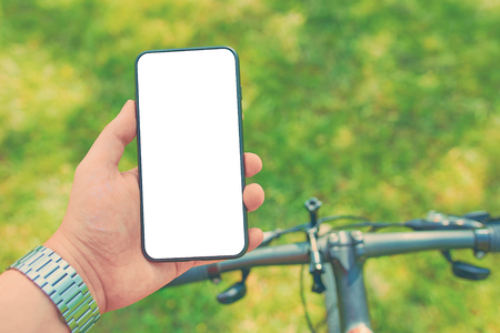 Man with a smartphone on a bike workout on offroad. Mock upの写真素材