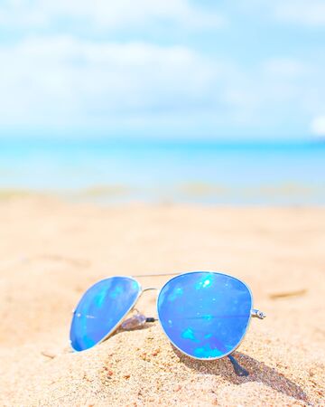Blue Sunglasses on the beach sand at sunny dayの写真素材