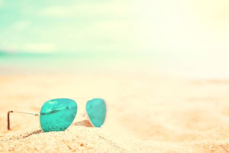 Green Sunglasses on the beach sand at sunny dayの写真素材