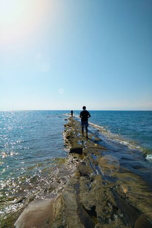 Group of friends walking on the beach before sunset in Sunny weatherの写真素材