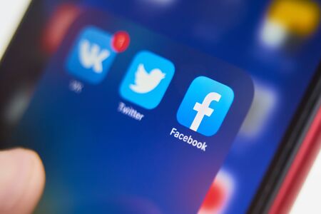 Bishkek, Kyrgyzstan - July 6 2019: Holding a Smartphone While Touching Facebook App Icon.のeditorial素材