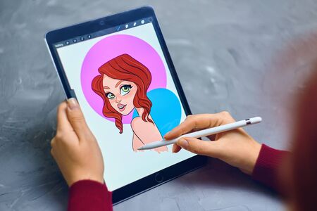 Bishkek, Kyrgyzstan - January 21, 2019: Woman Illustrator draws a portrait of a girl on an iPad Pro in procreate using apple pencilのeditorial素材