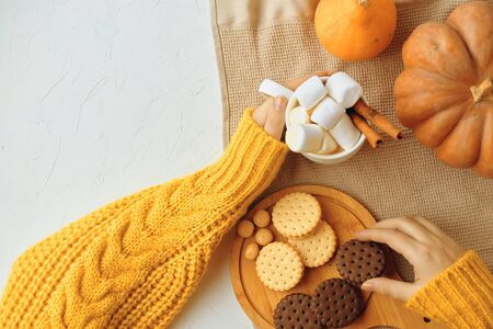Pumpkin Cookies With Cups Of Coffee. Pumpkin Spice Latte. In Female Hands. Woman drink Latte with Seasonal Autumn Spices and Cookies. Traditional Coffee Drink for Autumn Holidaysの写真素材