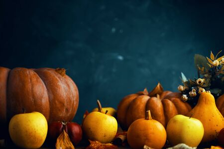 A bunch of pumpkins and apples. Happy Thanksgiving Day background, wooden table decorated with Pumpkins, fruits and autumn leaves.の写真素材