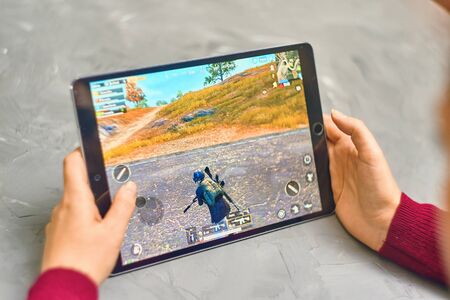 Bishkek, Kyrgyzstan - January 21, 2019: Woman playing pubg coop multiplayer battle royale game on Apple ios tablet iPad Proのeditorial素材