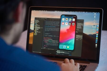 Bishkek, Kyrgyzstan - January 17, 2019: Man developer launches xcode software and ios simulator program to develop ios app on a MacBookのeditorial素材