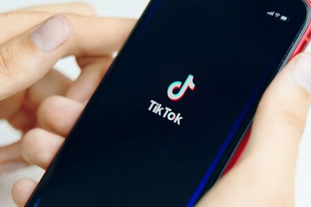Bishkek, Kyrgyzstan - June 6 2019: Iphone in hand. Tik Tok application icon on Apple iPhone X screen. Close-up.のeditorial素材