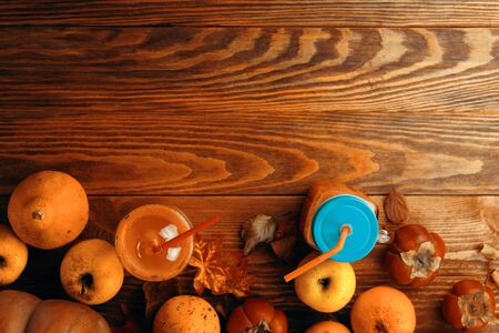 Pumpkins juice in bottles with pumpkins. Healthy pumpkin smoothie in big mugs on rustic backgroundの写真素材