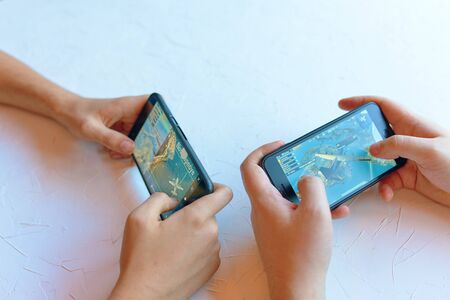 Bishkek, Kyrgyzstan - January 17, 2019: Two friends play pubg coop multiplayer battle royale game on iPhone and Android. Gameplay action flying on planeのeditorial素材