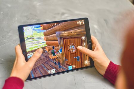 Bishkek, Kyrgyzstan - January 21, 2019: Woman playing fortnite game of epic games company on Apple ios tablet iPad Pro. Gameplay Actionのeditorial素材
