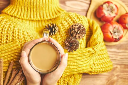 Autumn banner with yellow leaves, knitted jacket, pumpkins and cup of coffee on wooden textured backdrop. Fall background for thanksgiving day or seasonal sales card or flyer.の写真素材