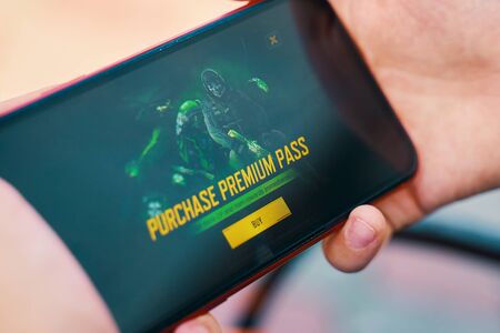 Bishkek, Kyrgyzstan - October 10, 2019: Premium pas purchase. Man playing online game in call of duty mobile on iphone 11のeditorial素材