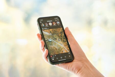 Bishkek, Kyrgyzstan - October 8 2019: Woman holds iphone 11 in dark mode with instagram app openのeditorial素材