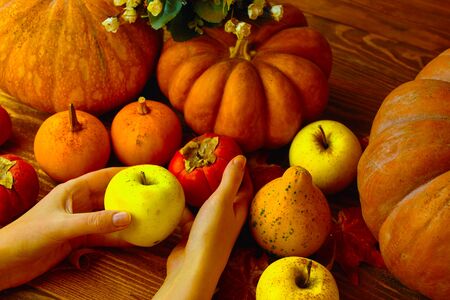 A bunch of pumpkins and apples. Autumn pumpkins on wooden board table. Top view with copy space.の写真素材