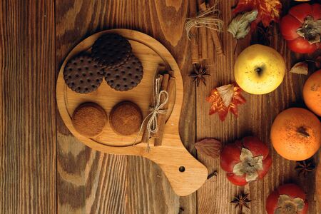Cookies with milk on the table. Cookies on a wooden Board with pumpkins and apples on the table.の写真素材
