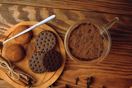 Milk and cookie on the table. Glass mug with chocolate milk on wooden table and near lies chocolate biscuits on a wooden plate. Top viewの写真素材