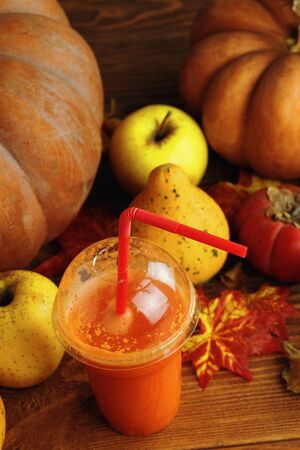 Pumpkins juice in bottles with pumpkins. The new crop of pumpkins. Pumpkin juice on the table.の写真素材