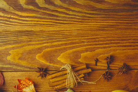 Wooden table. Autumn background with dry leaves, acorns cinnamon spices on wooden table. Copy space. Autumn background with dry leaves, cinnamon spices onの写真素材