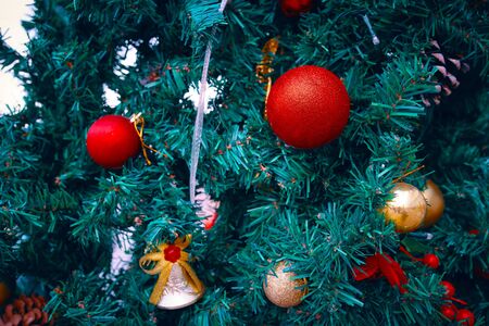 Decorating Christmas tree close up. Decoration green fir tree, golden red christmas toys and lights. Use for Christmas and New years.の写真素材