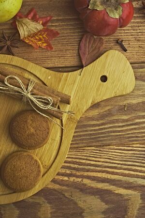 Cookies with pumpkins and apples on the table. Chocolate cookies with apples and pumpkins are on a wooden table.の写真素材