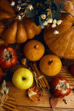 A bunch of pumpkins and apples. Fresh pumpkin on a wooden table. Pair of ripe pumpkins on a wooden tableの写真素材
