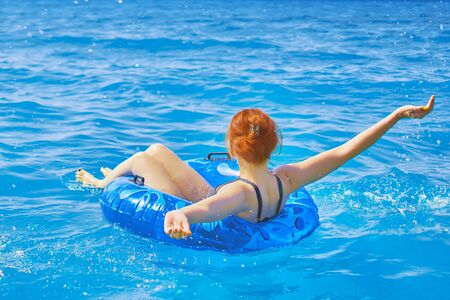 Awesome young woman relax on inflatable ring make water splatter in sea waterの写真素材