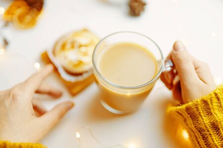 Coffee and cake with cream on the table. Female drinking latte and eating cake.の写真素材